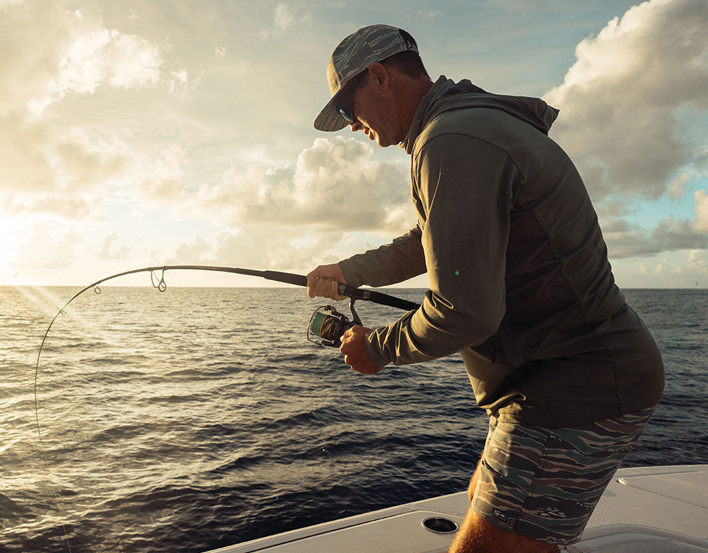 Angler fighting a fish from a boat, wearing Pelagic gear in Mangrove